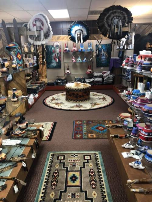 A vibrant store interior showcasing Native American crafts, including pottery, rugs, and decorative items.