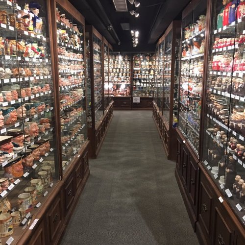 A narrow aisle between glass display cases filled with various collectible figurines and memorabilia.