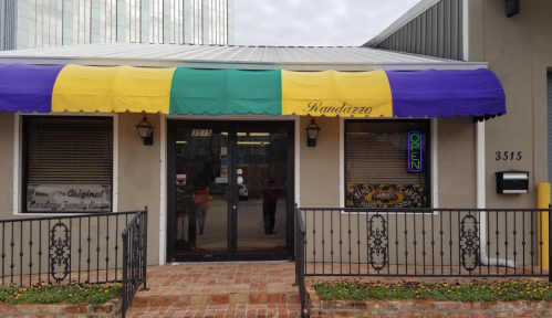 Exterior of Randazzo's with a colorful awning, open sign, and brick walkway.