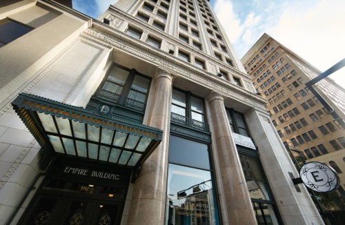 Exterior view of the Empire Building, showcasing its tall structure and ornate entrance with decorative awning.