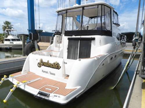 A white boat named "Soulmates" docked at a marina in Kemah, Texas, with a clear blue sky in the background.