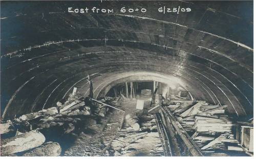 Black and white photo of a tunnel interior, showing wooden beams and debris, dated June 25, 1909.