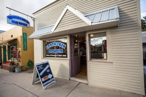 Exterior of Upashkin BBQ House, a small restaurant with a sign indicating it's known for Montana's best BBQ.