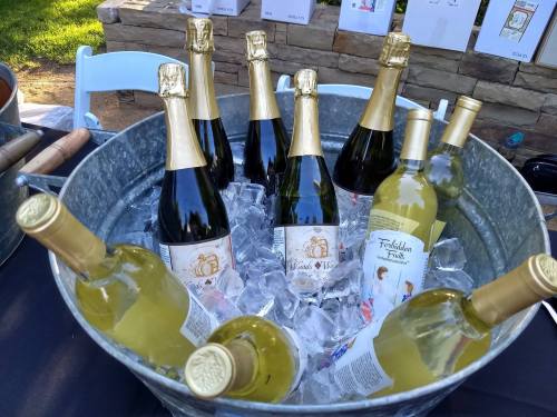 A metal tub filled with ice and bottles of white and sparkling wine.