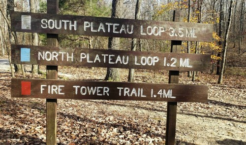 Trail sign with three routes: South Plateau Loop 3.5 miles, North Plateau Loop 1.2 miles, Fire Tower Trail 1.4 miles.
