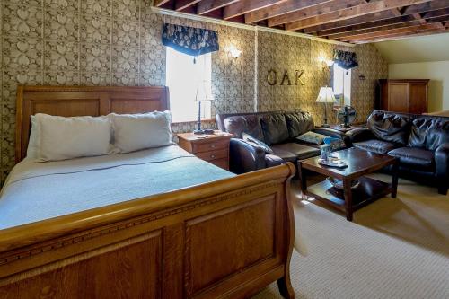 Cozy bedroom with a wooden bed, leather sofas, and decorative wallpaper, featuring a warm, inviting atmosphere.