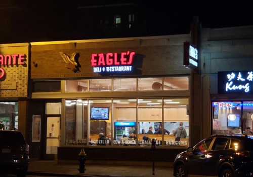A nighttime view of Eagle's Deli & Restaurant, featuring bright signage and a busy interior with patrons.