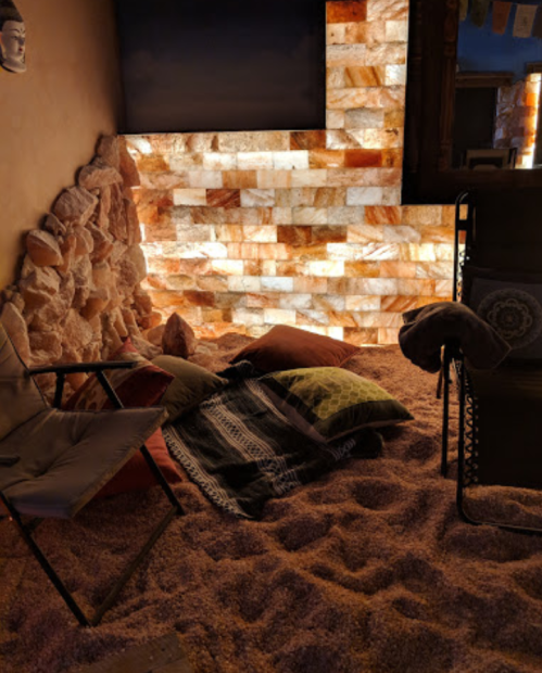 Cozy relaxation area with salt wall, cushions, and a sandy floor, creating a tranquil atmosphere.