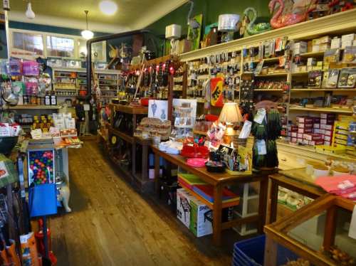 A colorful, cluttered store interior filled with various items, including toys, kitchenware, and decorations.