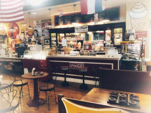 A vintage ice cream parlor with a red and white counter, nostalgic decor, and a cozy seating area.