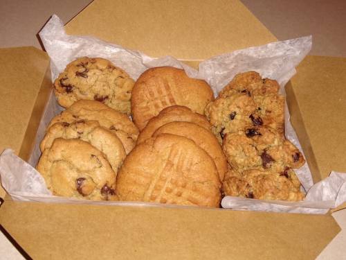 A box filled with assorted cookies, including chocolate chip, peanut butter, and oatmeal raisin varieties.