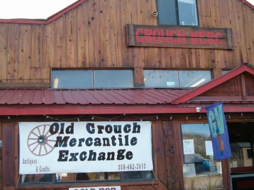 Sign for "Old Crouch Mercantile Exchange" on a wooden building, featuring antiques and crafts.