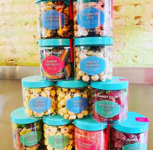 A colorful display of various candy jars stacked on top of each other, featuring different sweet treats.