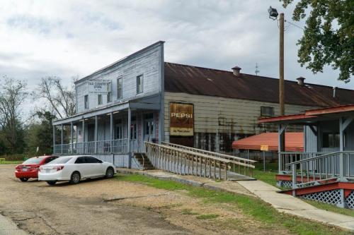 Old country store with a Pepsi sign, featuring a wooden ramp and a rustic exterior under a cloudy sky.