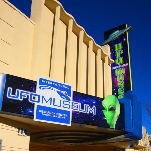 Exterior of the International UFO Museum in Roswell, New Mexico, featuring an alien graphic and colorful signage.