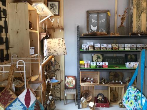 A cozy shop interior featuring handmade crafts, decor items, and wooden shelves filled with various products.