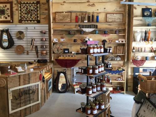 A cozy shop interior featuring wooden shelves filled with handmade crafts, jars, and various decorative items.