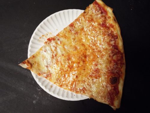 A slice of cheese pizza on a paper plate, with melted cheese and a golden crust.