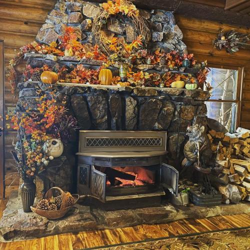 Cozy fireplace with a stone surround, adorned with autumn decorations, pumpkins, and a wooden floor.
