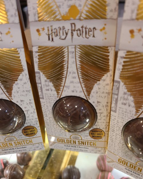 Packaging for a Harry Potter-themed chocolate treat shaped like a Golden Snitch, featuring gold and white design elements.