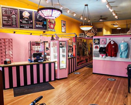Brightly colored ice cream shop interior with pink walls, a service counter, and merchandise displays.