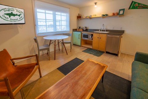 Cozy interior of a small kitchen and living area with a table, chairs, and modern appliances. Bright and inviting space.