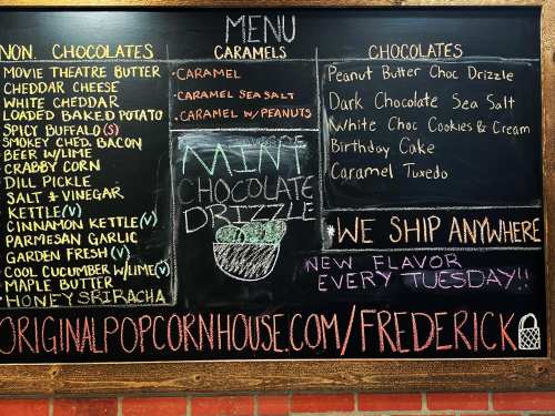 Chalkboard menu listing chocolates and caramels, including flavors like Movie Theater Butter and Peanut Butter Choc Drizzle.