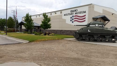 Exterior of the Idaho Military Museum featuring a tank and American flag mural on the building.