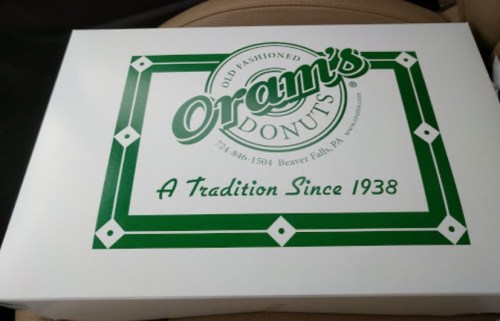 A white donut box with green accents, labeled "Oram's Donuts" and "A Tradition Since 1938."