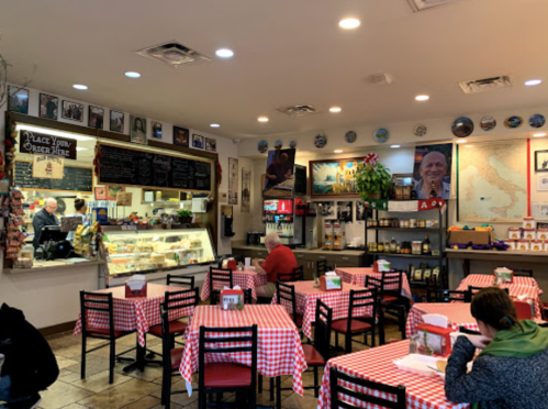 Cozy restaurant interior with checkered tablecloths, a counter, and walls adorned with photos and decor.