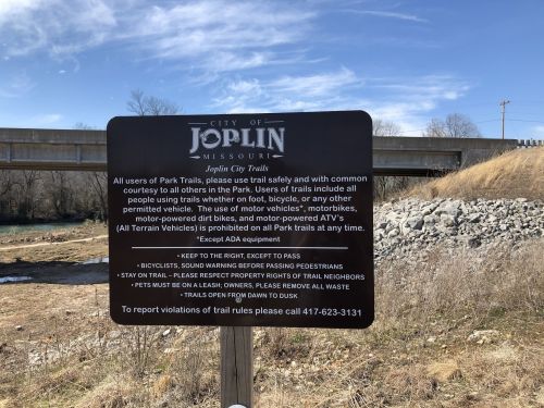 Sign for Joplin City Trails outlining safety rules and regulations for trail users, including restrictions on vehicles and pets.
