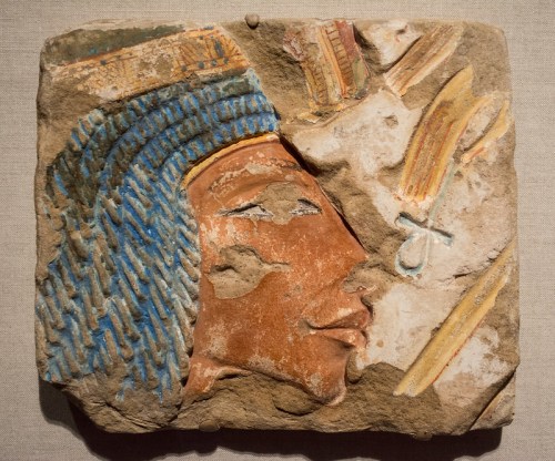 Ancient Egyptian relief depicting a profile of a figure with blue headdress and colorful details on stone.
