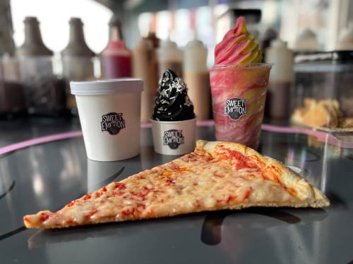 A slice of cheese pizza with two dessert cups: one with soft serve and one with a swirl of pink and yellow ice cream.