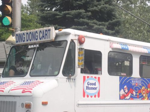 A colorful ice cream truck with "DING DONG CART" signage and Good Humor branding, stopped at a traffic light.