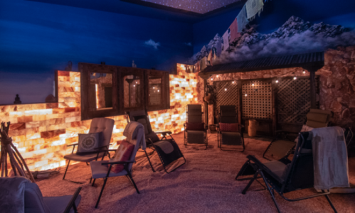 A cozy relaxation room with salt wall, reclining chairs, and a starry ceiling, creating a tranquil atmosphere.