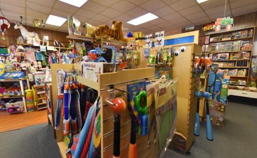 A colorful toy store aisle filled with various toys, games, and stuffed animals on display.