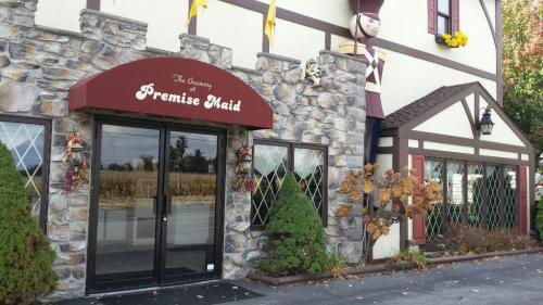 Exterior of a stone building with a sign reading "The Cleaning at Premise Maid," featuring decorative plants and a nutcracker figure.