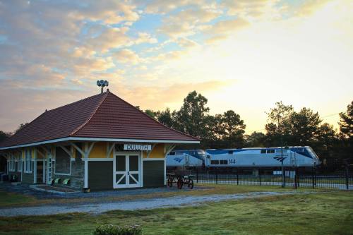 Historic train station in Duluth at sunrise, with a train parked nearby and a colorful sky in the background.
