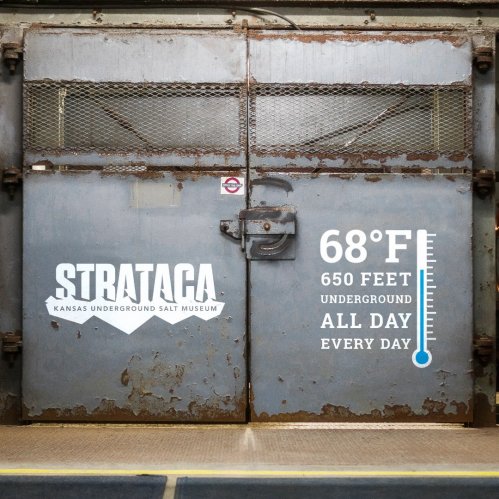 A large metal door with "STRATACA Kansas Underground Salt Museum" and temperature details displayed on it.