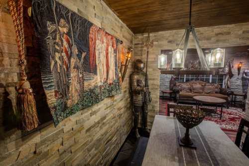 A cozy room featuring a tapestry, stone walls, a knight statue, and rustic furniture with warm lighting.