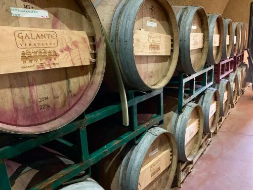 Wooden wine barrels stacked on racks, labeled with "Galante Vineyards" and vintage year 2014.