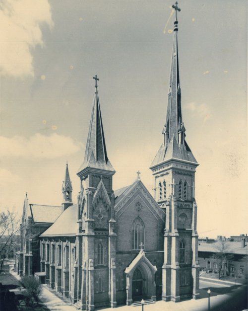 Historic church with two tall spires, intricate stonework, and a large entrance, set against a clear sky.