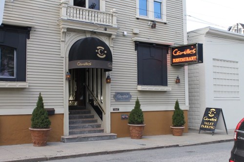 Exterior of Carnille's Restaurant featuring a staircase entrance, potted plants, and valet parking sign.