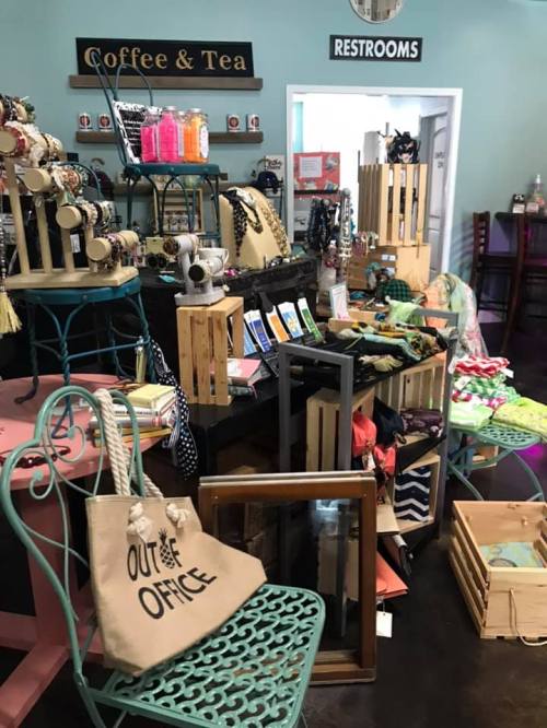 A cozy shop display featuring coffee, tea, and various handmade items, with colorful accessories and decor.