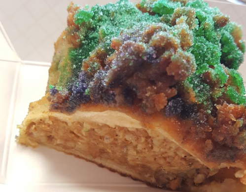 A slice of dessert topped with colorful sprinkles and a crumbly, textured topping.