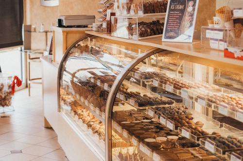 A display case filled with various chocolates and desserts in a cozy shop setting.