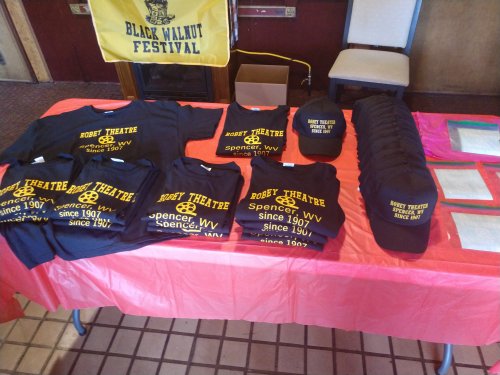 T-shirts and hats for the Robert Theatre, displayed on a table at the Black Walnut Festival.