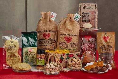 A variety of gourmet snacks including pistachios, cookies, coffee, and corn bread displayed on a red tablecloth.
