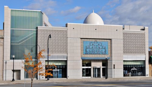 Exterior view of the Arab American National Museum, featuring modern architecture and a decorative blue tile mural.