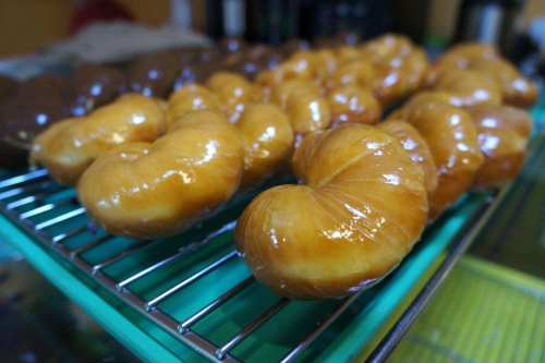 A close-up of shiny, golden-brown pastries arranged on a wire rack, showcasing their glossy finish.
